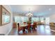 Dining room featuring a wooden table, chandelier, large windows with natural light, and hardwood floors at 100 Maple Leaf Rd, Sharpsburg, GA 30277