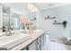 Bathroom with dual sinks, a large mirror, decorative shelves, and a bathtub with shower at 1211 Fly Rod Ln, Loganville, GA 30052