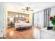 Spacious main bedroom with a tufted headboard, wood floors, and a ceiling fan with a light at 1211 Fly Rod Ln, Loganville, GA 30052