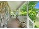Covered front porch with stone facade and white railing at 1211 Fly Rod Ln, Loganville, GA 30052