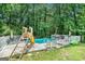 Outdoor in-ground swimming pool surrounded by a deck, lounge chairs and lush trees at 1211 Fly Rod Ln, Loganville, GA 30052