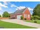 Exterior view of the brick garage with a spacious driveway and well-maintained lawn, enhancing curb appeal at 161 Pleasant Grove Rd, Mcdonough, GA 30252