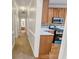 Hallway view of the kitchen with white countertops, wooden cabinets, stainless appliances, and light-colored backsplash at 161 Pleasant Grove Rd, Mcdonough, GA 30252