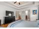 Bedroom boasts tray ceiling, wood floors, TV on dresser, and bathroom and closet access at 207 Brookstone Dr, Carrollton, GA 30116