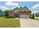Charming home featuring stone and blue siding, a well-manicured lawn, and an attached two-car garage at 207 Brookstone Dr, Carrollton, GA 30116