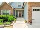 Inviting front porch adorned with stone accents, plants, and a charming door featuring the house number at 207 Brookstone Dr, Carrollton, GA 30116