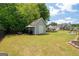 Charming backyard shed with a grill and canopy, surrounded by a lush, well-maintained lawn at 207 Brookstone Dr, Carrollton, GA 30116