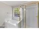 Bright bathroom with a garden tub, shower with glass door, and a window with backyard views at 30 Stonewall Dr, Covington, GA 30016