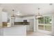 Bright kitchen with stainless steel microwave, white cabinets, granite counters and pendant lighting at 30 Stonewall Dr, Covington, GA 30016
