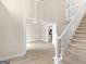 The staircase stands beside a dining area with views into the kitchen, showcasing an open concept design at 30 Stonewall Dr, Covington, GA 30016