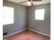 Neutral bedroom featuring two windows, a ceiling fan, and laminate flooring at 1028 Dixie Dr, Jonesboro, GA 30236