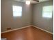 This bedroom features a ceiling fan, two windows, and hardwood flooring at 1028 Dixie Dr, Jonesboro, GA 30236