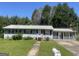 Modest one-story home with a traditional design, lawn, and mailbox, shaded by mature trees at 1028 Dixie Dr, Jonesboro, GA 30236