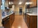 Well-lit kitchen with dark wood cabinets, laminate floors, and modern appliances at 1028 Dixie Dr, Jonesboro, GA 30236