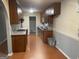Functional kitchen with wooden cabinets, laminate floors, and an adjoining room at 1028 Dixie Dr, Jonesboro, GA 30236
