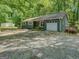 Charming home featuring a one-car garage, front patio, and a gravel driveway surrounded by mature trees at 357 Oak Hill Rd, Covington, GA 30016