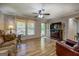 Comfortable living room with wood-look flooring, ceiling fan, and a large window providing natural light at 357 Oak Hill Rd, Covington, GA 30016