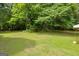 Lush backyard features mature trees and a spacious lawn, perfect for outdoor activities and relaxation at 74 Price W Dr, Locust Grove, GA 30248
