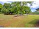 Spacious backyard with a fenced in area, large trees, and open space at 74 Price W Dr, Locust Grove, GA 30248
