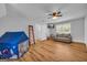 Bright bonus room features a gray sofa, a television, wood floors, and a fun play tent at 74 Price W Dr, Locust Grove, GA 30248