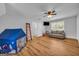 Bright bonus room features a gray sofa, a television, wood floors, and a fun play tent at 74 Price W Dr, Locust Grove, GA 30248