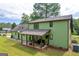 Two-story home featuring a covered patio, green siding, and a spacious backyard at 74 Price W Dr, Locust Grove, GA 30248
