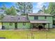 Back view of a green two-story house with a covered patio and a fenced backyard at 74 Price W Dr, Locust Grove, GA 30248