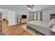 This primary bedroom features wood floors, a ceiling fan, and neutral decor at 74 Price W Dr, Locust Grove, GA 30248