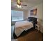 Cozy bedroom featuring hardwood floors, a ceiling fan, sunset artwork and a large window at 312 Archway Ln, Peachtree City, GA 30269