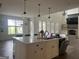 Open-concept kitchen showcasing a center island with bar seating, pendant lights, and a view of the breakfast and fireplace at 312 Archway Ln, Peachtree City, GA 30269