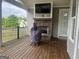 Covered porch with a brick fireplace, mounted television, and a view of the surrounding landscape at 312 Archway Ln, Peachtree City, GA 30269