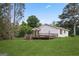 Back exterior featuring a wooden deck and spacious green lawn, perfect for outdoor enjoyment at 885 Kelleytown Rd, Mcdonough, GA 30252
