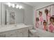 Bright bathroom featuring a white vanity, large mirror, and a colorful shower curtain at 885 Kelleytown Rd, Mcdonough, GA 30252