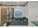 Bathroom with a large tub under a window, and a glass shower stall at 885 Kelleytown Rd, Mcdonough, GA 30252