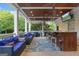 Inviting covered patio with an outdoor kitchen, comfortable seating, and a mounted television at 885 Kelleytown Rd, Mcdonough, GA 30252