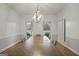 Dining room with decorative light fixture, views to the backyard, and a light-colored wood table with gray chairs at 885 Kelleytown Rd, Mcdonough, GA 30252