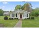 Charming white house with a red door and well-manicured lawn, offering classic curb appeal at 885 Kelleytown Rd, Mcdonough, GA 30252