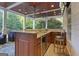 Outdoor kitchen features a granite countertop, wood ceiling, stainless fridge and lush landscape views at 885 Kelleytown Rd, Mcdonough, GA 30252