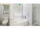 Bathroom features soaking tub below window and glass-enclosed shower at 1010 Capella Creek Way, Grayson, GA 30017