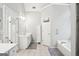 Bathroom with dual vanities, tile floors, soaking tub, and neutral color palette at 1010 Capella Creek Way, Grayson, GA 30017