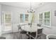Cozy dining area features a white dining set, stylish chandelier and is flooded with natural light from two windows at 1010 Capella Creek Way, Grayson, GA 30017