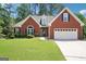 Charming single-story brick home featuring a two-car garage and well-manicured lawn and shrubs at 1010 Capella Creek Way, Grayson, GA 30017