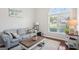 Sunlit living room featuring an oversized window, plush carpeting, and comfortable seating, perfect for relaxation and entertaining at 1010 Capella Creek Way, Grayson, GA 30017