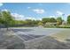 Outdoor tennis court with net, surrounded by greenery, with a covered area in the background at 1010 Capella Creek Way, Grayson, GA 30017