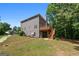Two-story home featuring a wood deck, backyard space, and gray siding on a sunny day at 1429 Kentmire Court, Locust Grove, GA 30248
