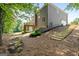 Landscaped backyard featuring a two-story home with a wood deck and garden steps on a sunny day at 1429 Kentmire Court, Locust Grove, GA 30248