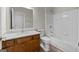 Bathroom featuring a wooden vanity with granite countertop and a white tiled shower and tub at 1429 Kentmire Court, Locust Grove, GA 30248