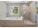 A closer view of the bright bathroom with a soaking tub and a glass-enclosed shower at 1429 Kentmire Court, Locust Grove, GA 30248