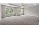 Carpeted bedroom featuring a ceiling fan and two windows overlooking a neighborhood view at 1429 Kentmire Court, Locust Grove, GA 30248