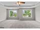 Bedroom showcasing a ceiling fan and two windows overlooking a neighborhood view at 1429 Kentmire Court, Locust Grove, GA 30248
